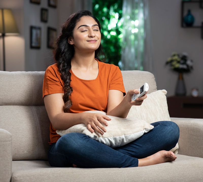 Women on couch smiling and breathing in clean healthy air